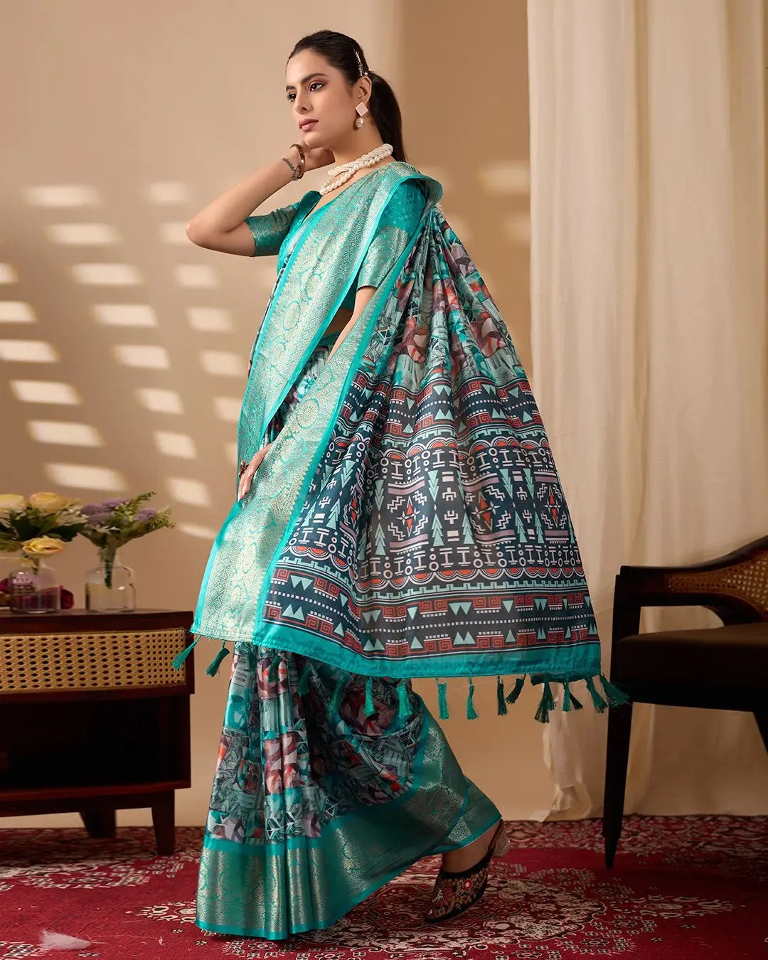 Woman wearing a traditional saree with a patterned design in a room setting.
